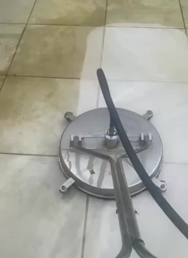 Rotary surface cleaner mid-clean on a patio, the cleaned half already pale Rotary surface cleaner mid-clean on a patio, the cleaned half already pale